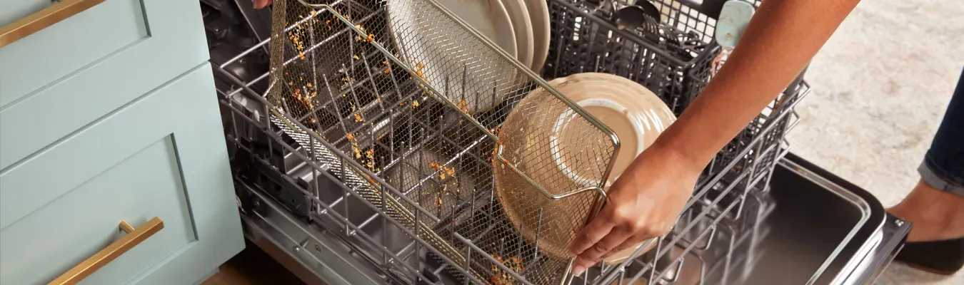 womans-hand-loading-dishwasher